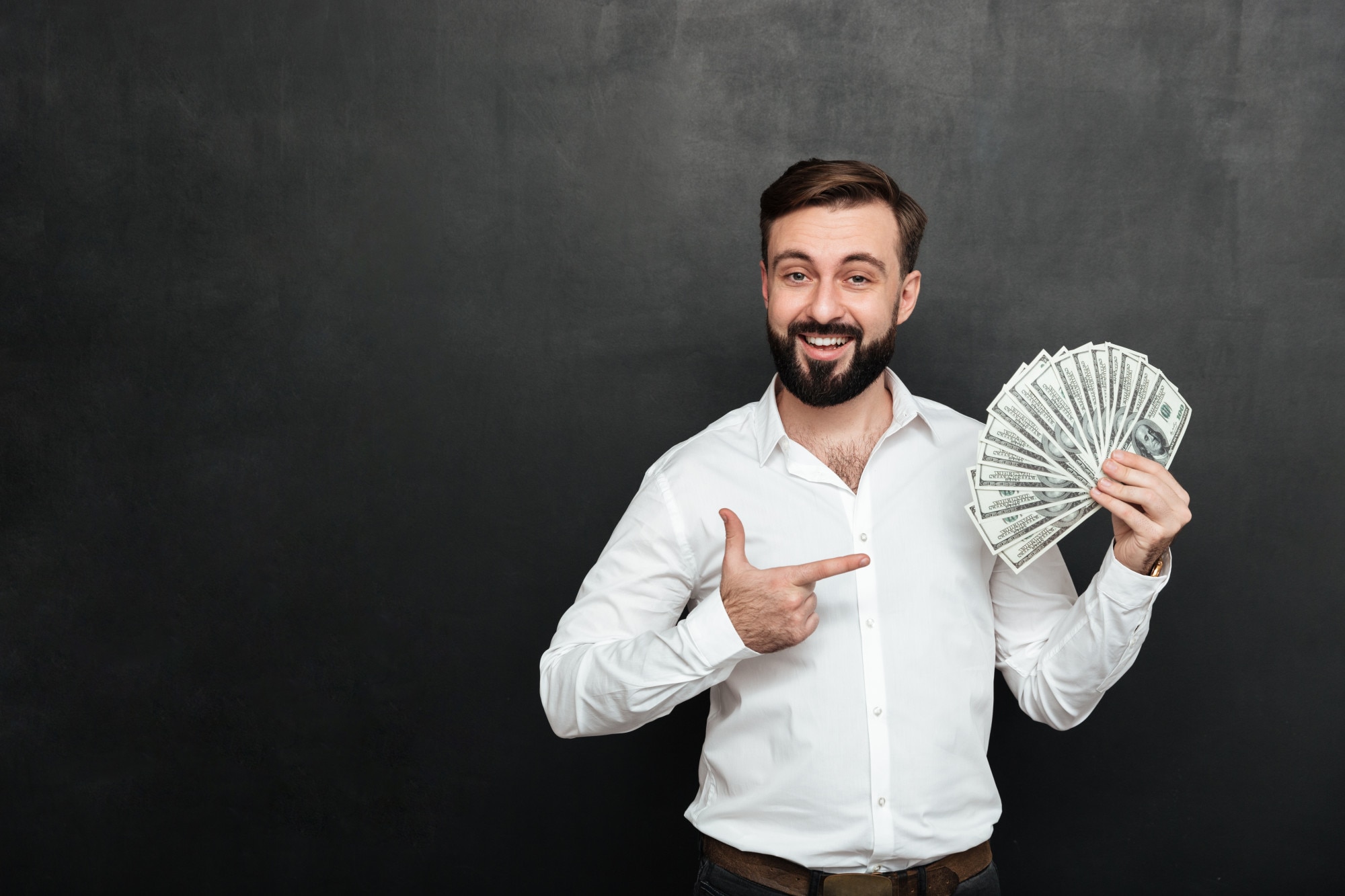 portrait-adult-man-white-shirt-posing-camera-with-fan-100-dollar-bills-hand-being-rich-happy-dark-gray_171337-588