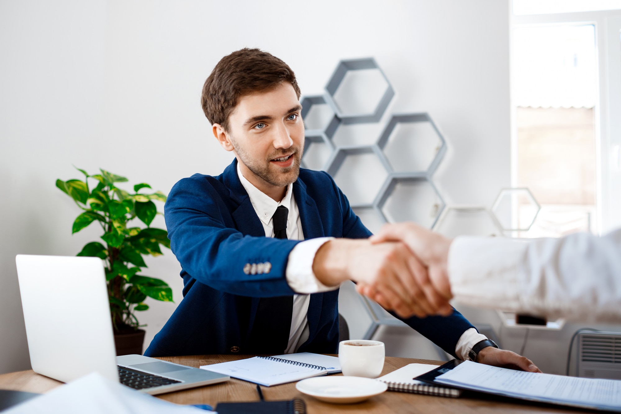 young-successful-businessman-sitting-workplace-office-background_176420-5265