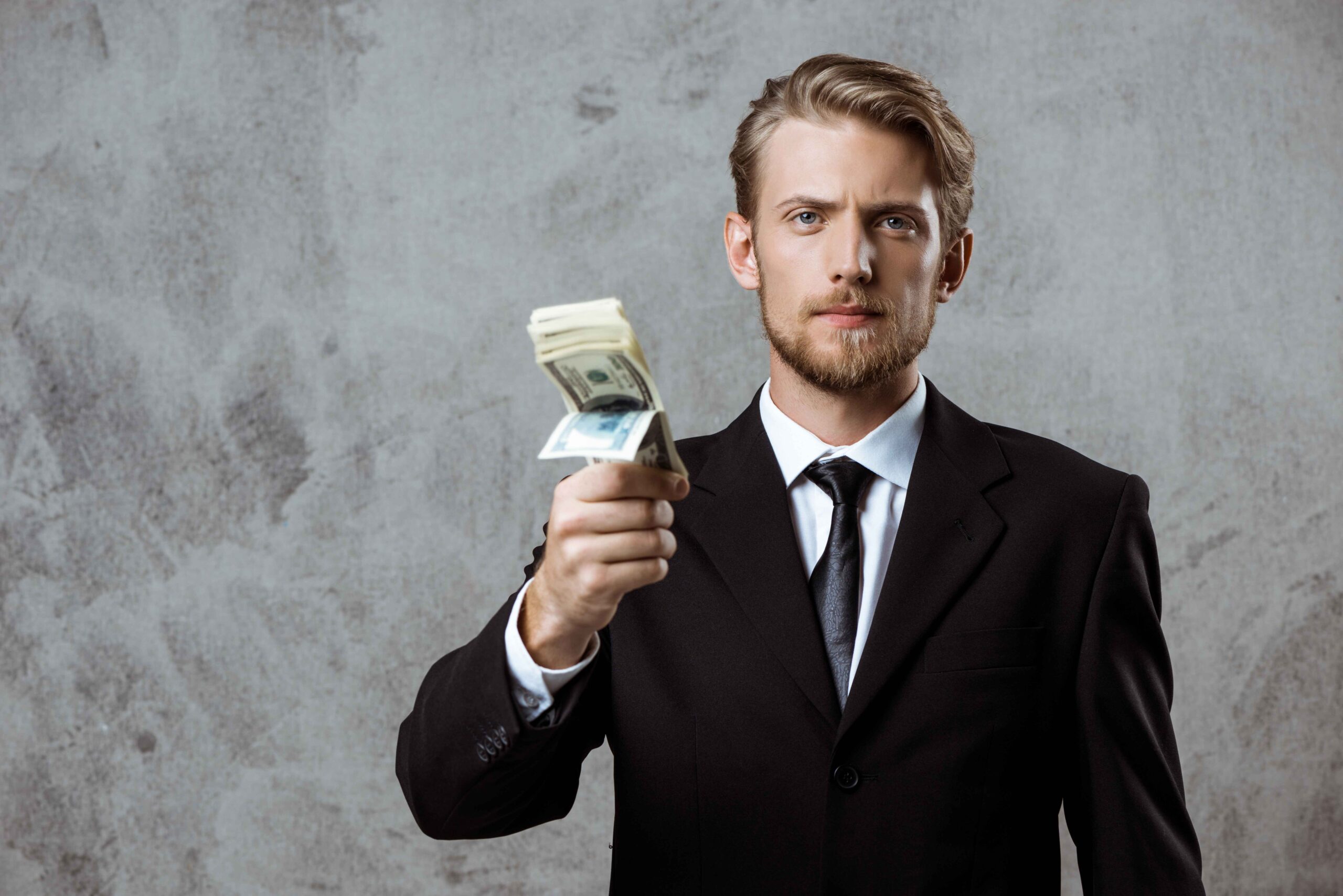 young-successful-businessman-suit-holding-money