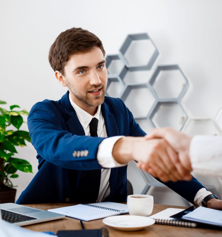 young-successful-businessman-sitting-workplace-office-background_176420-5265